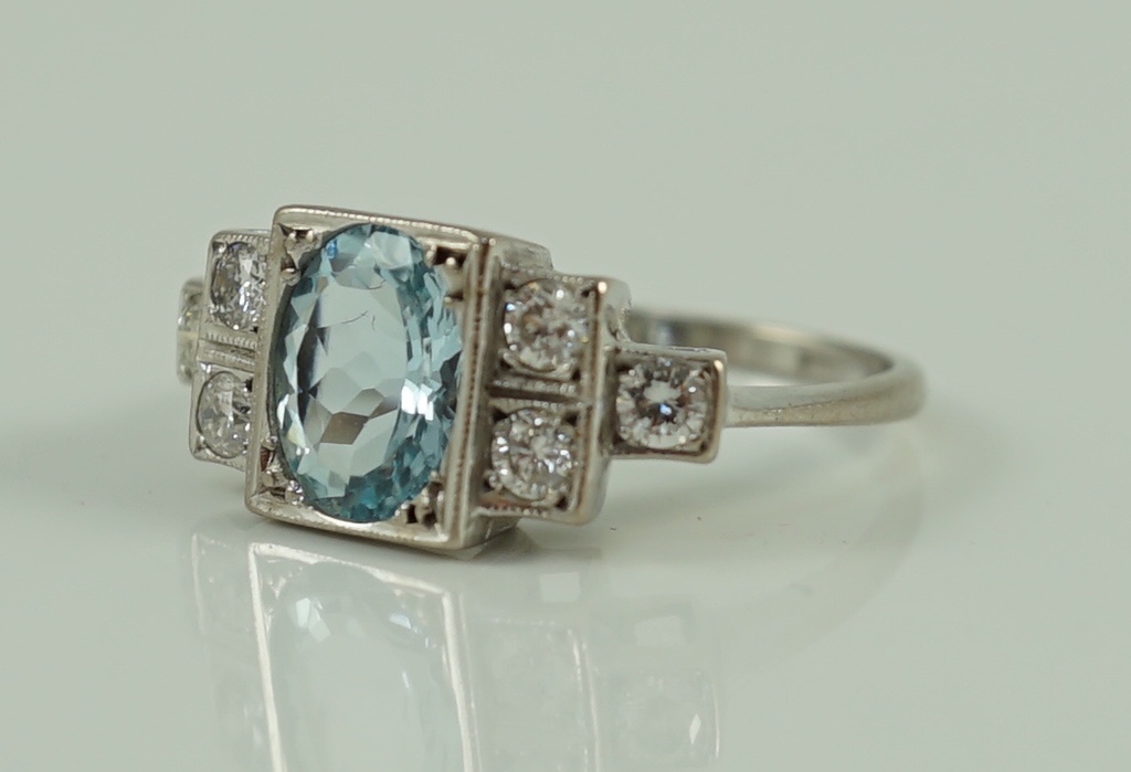 An 18ct white gold oval cut aquamarine and six stone diamond cluster set dress ring